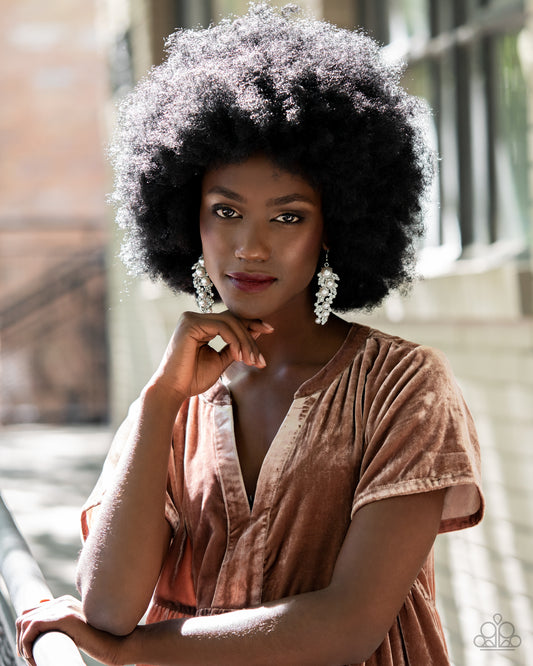 An explosion of glittery white rhinestones and oversized pearls coalesce into an exaggerated leafy silver lure, creating a dramatic statement piece. Earring attaches to a standard fishhook fitting.  Sold as one pair of earrings.